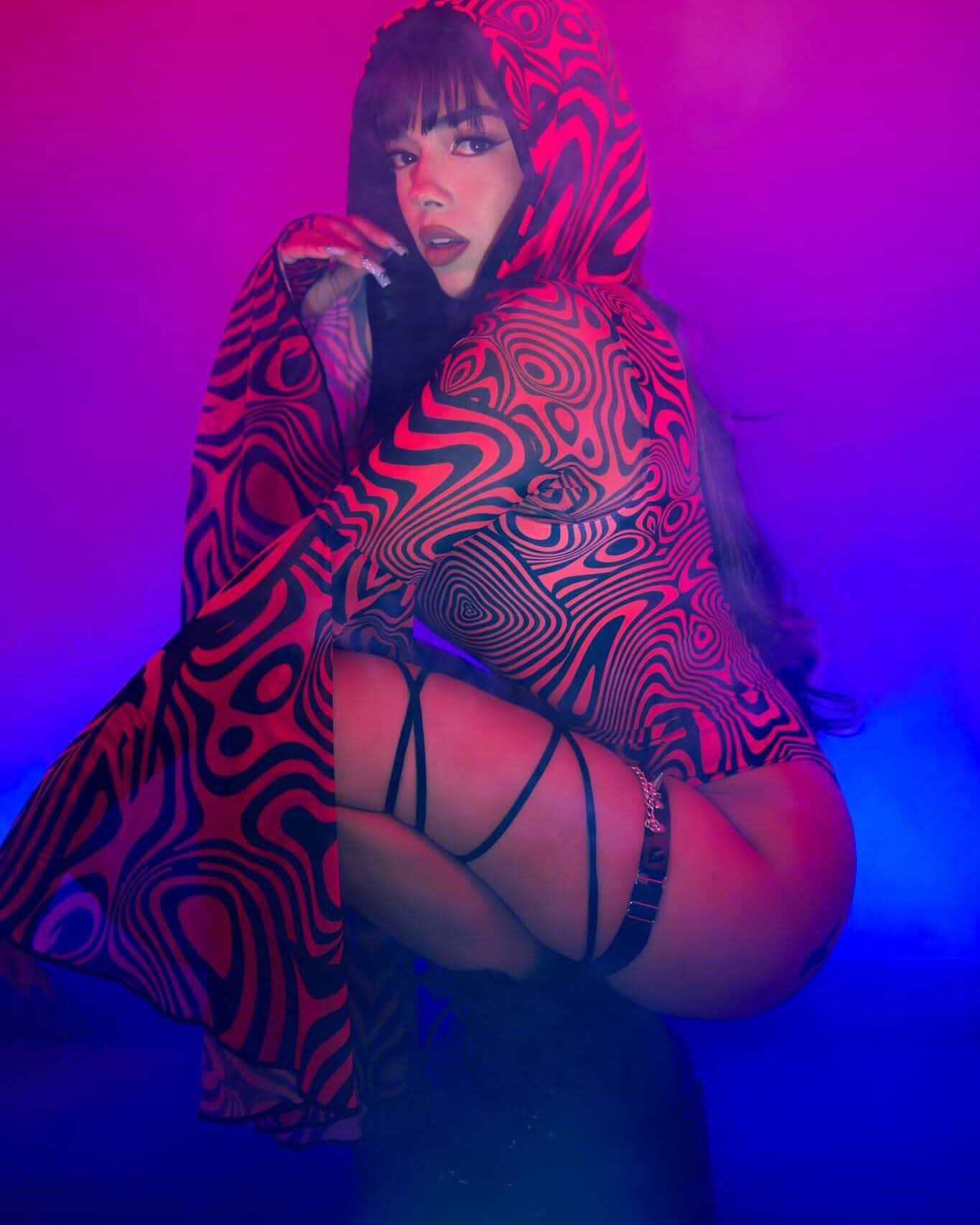 Model showcasing a striking Red Void Assassin Hood in a vibrant cyberpunk setting, ideal for rave outfits and cosplay.
