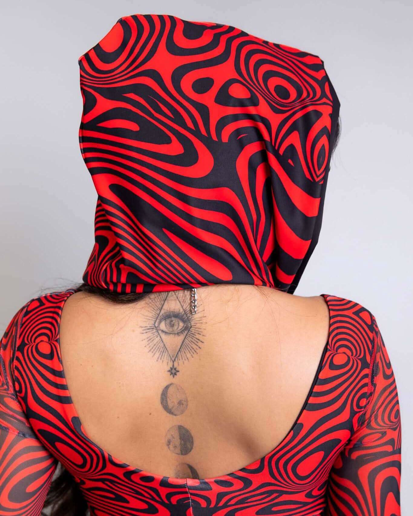 Woman wearing a Red Void Assassin Hood featuring bold red and black patterns, showcasing an edgy cyberpunk look.
