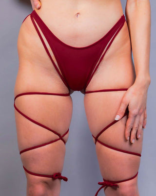 Scarlet strappy high hip bikini bottoms styled for rave outfits, showcasing a sultry design and cheeky cut.