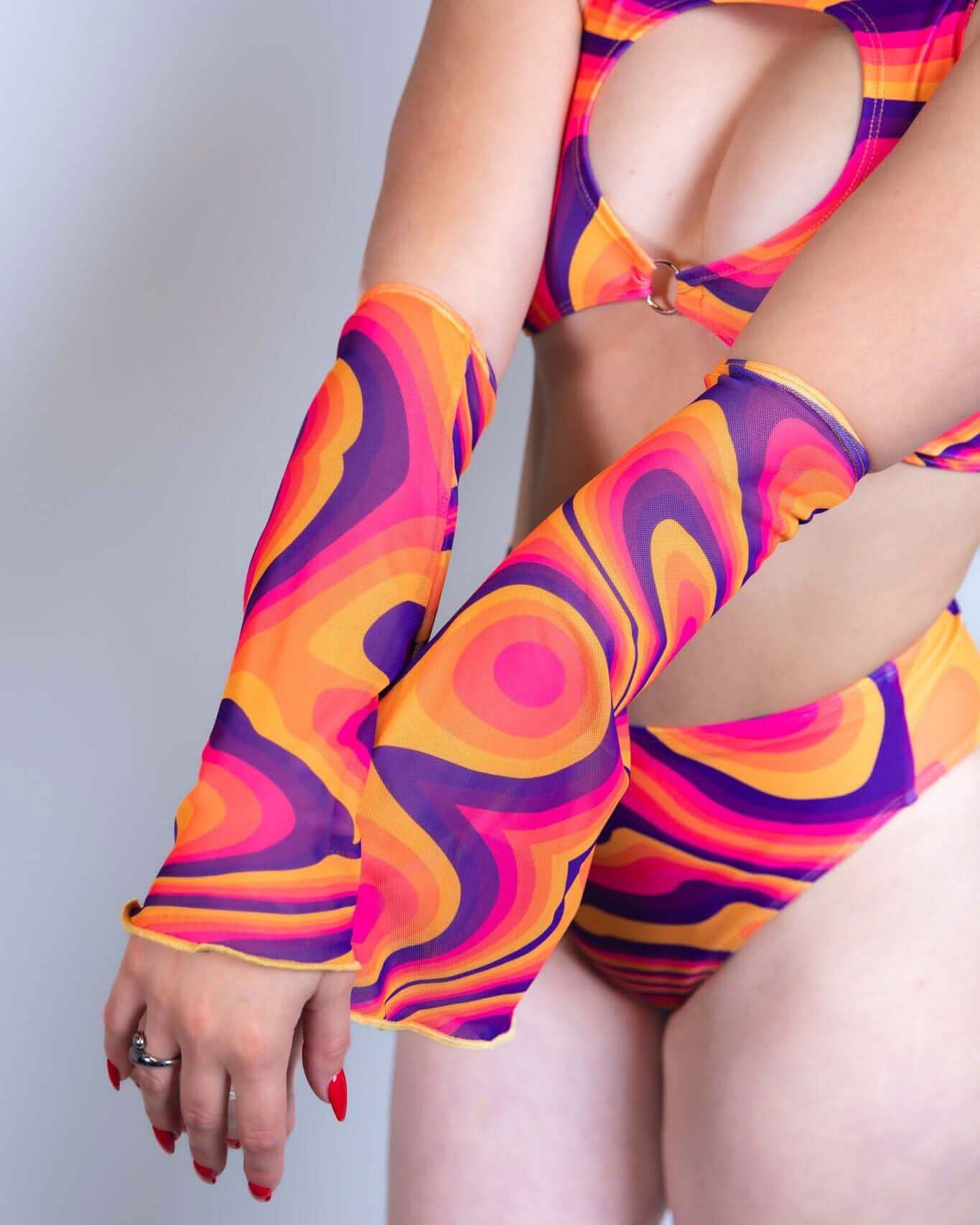 Woman showcasing vibrant Tangerine Tango Mesh Flare Sleeves as part of a colorful rave outfit.
