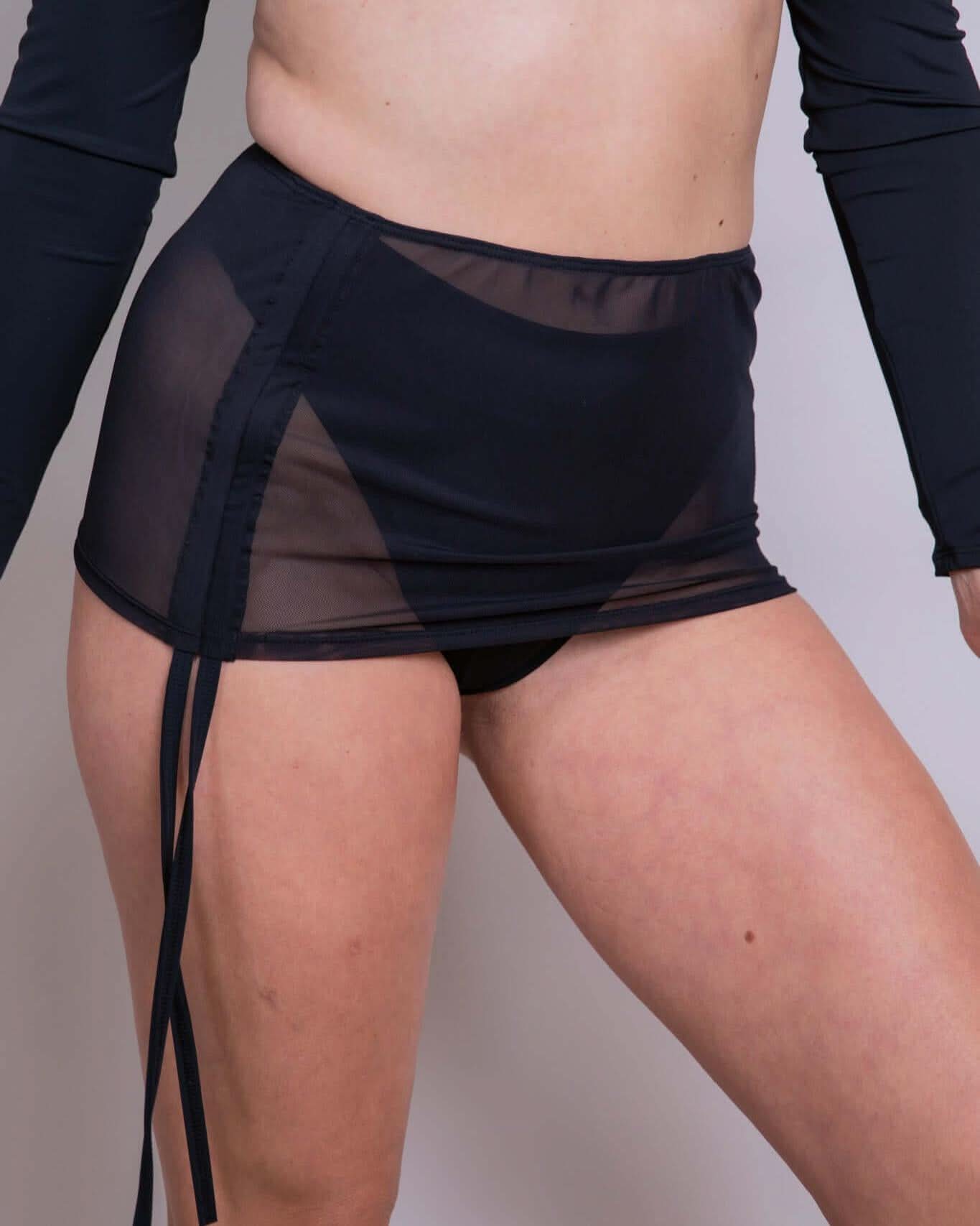 Black mesh cinch skirt with adjustable drawcord for customizable length, perfect for rave outfits and all occasions.