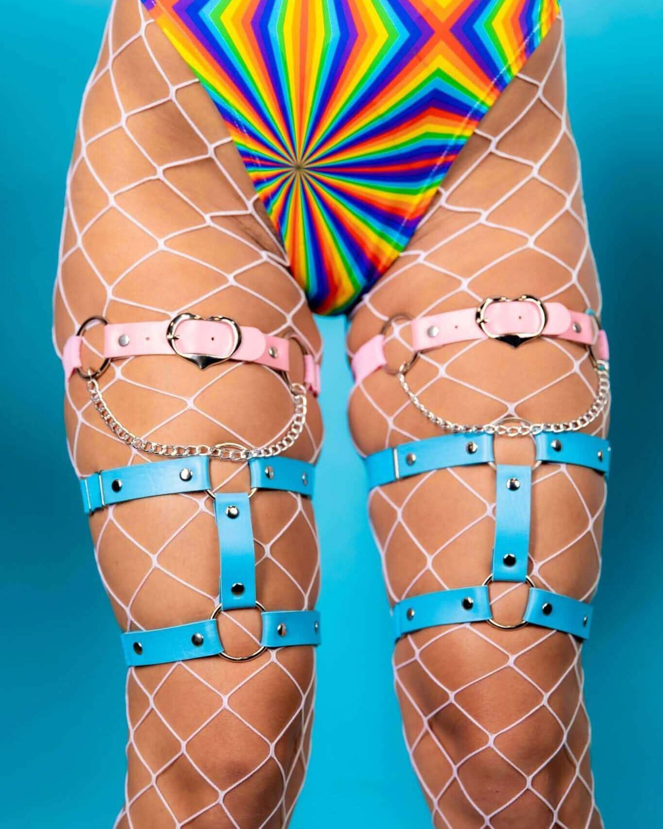 Heartbreaker leg garter in pink and blue worn over fishnet stockings, perfect for rave outfits and festival fashion.