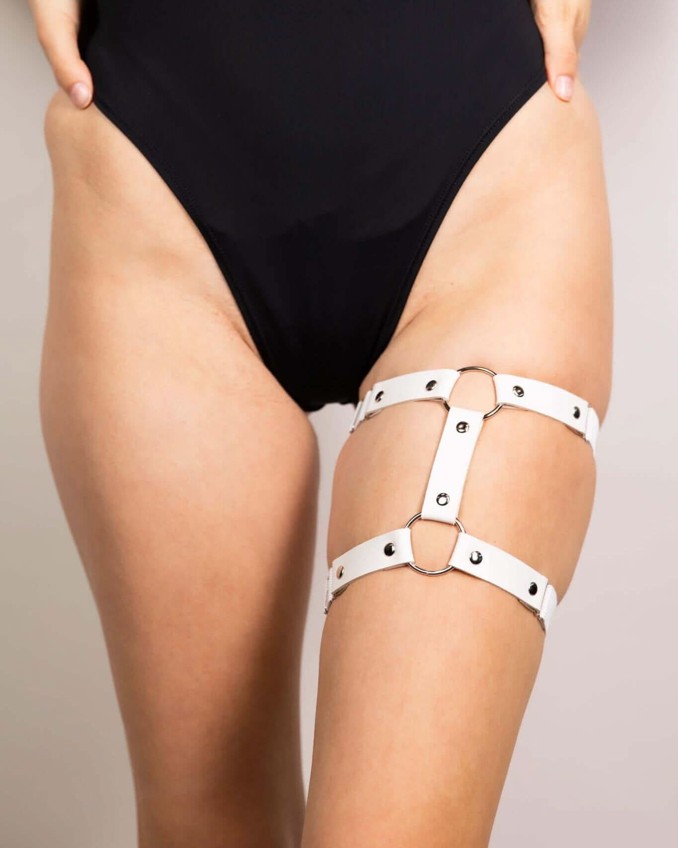 White leather adjustable leg garter, perfect for edgy rave outfits and festival fashion, showcasing stylish details.