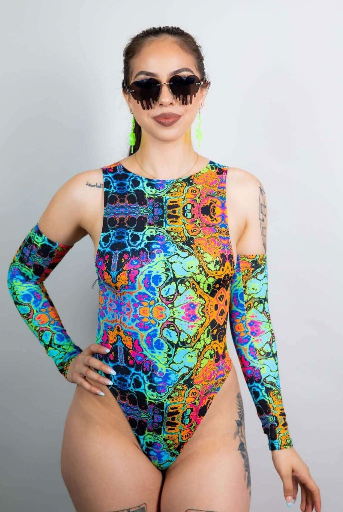 Model showcasing the Lucidity Sideboob Bodysuit with psychedelic rainbow print, perfect for rave outfits.