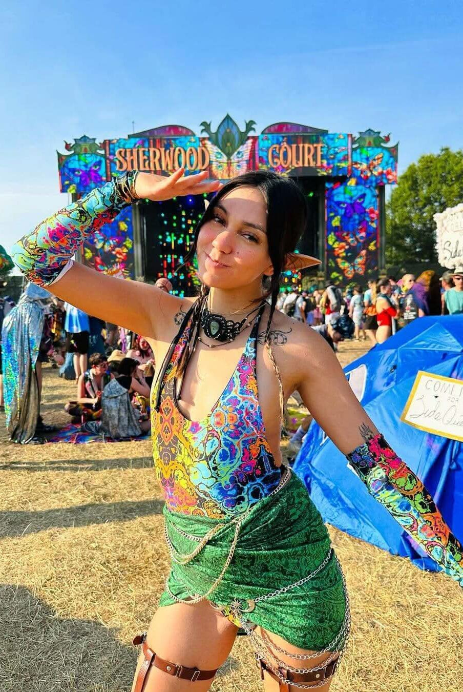 Festival-goer in rainbow rave outfit posing at Sherwood Court, showcasing vibrant festival style and energy.