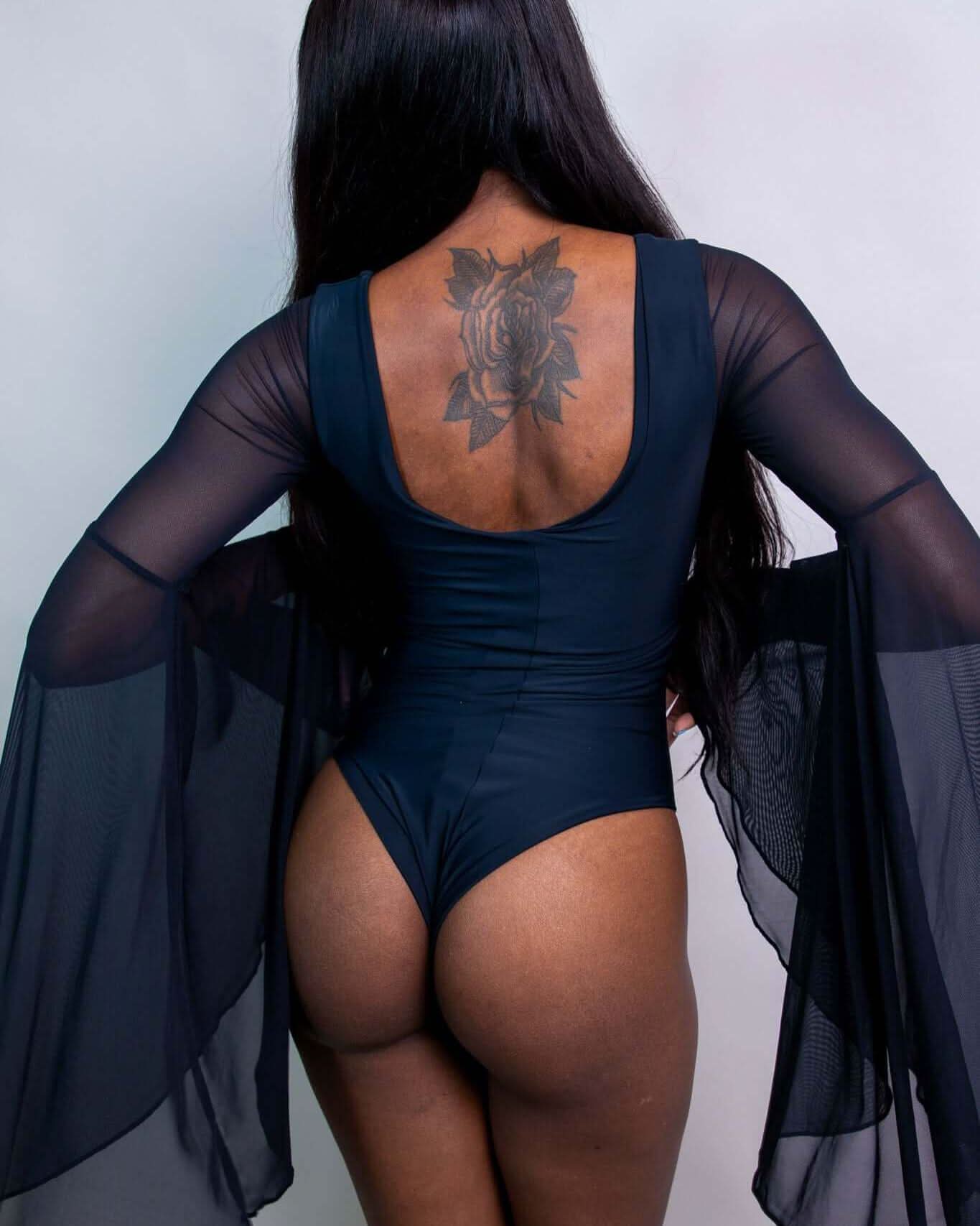 Matte Black Goddess Bodysuit showcasing lace-up detail, mid-hip cut, and dramatic circle sleeves, ideal for rave outfits.