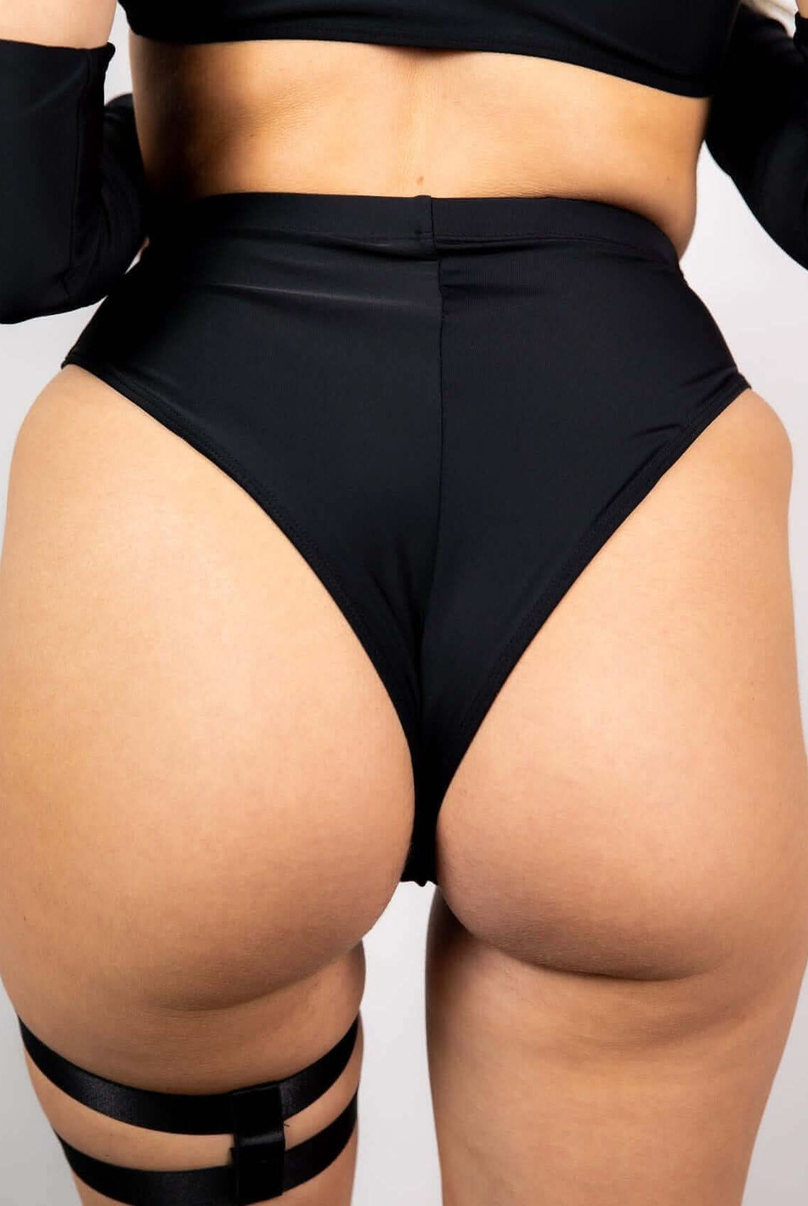 High waisted matte black Brazilian bottoms for a cheeky look, perfect for rave outfits.