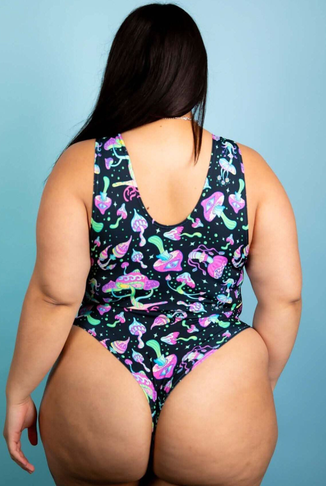 Back view of plus-size individual wearing a psychedelic mushroom bodysuit, perfect for rave outfits and festivals.