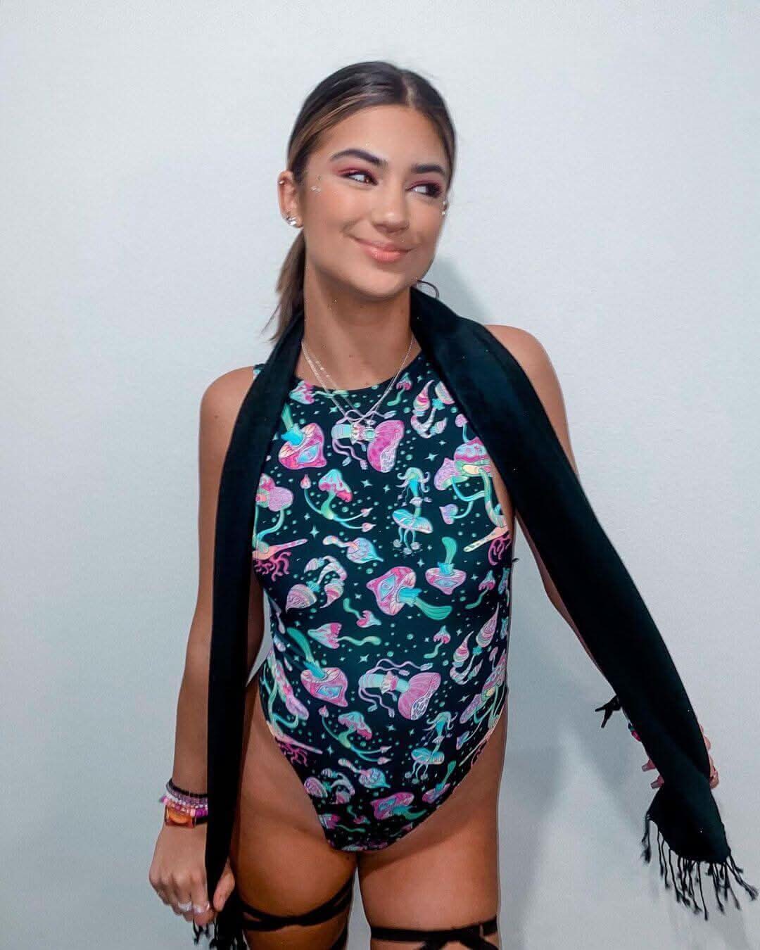 Model wearing the Mushies sideboob bodysuit with psychedelic mushroom print, perfect for rave outfits and festivals.