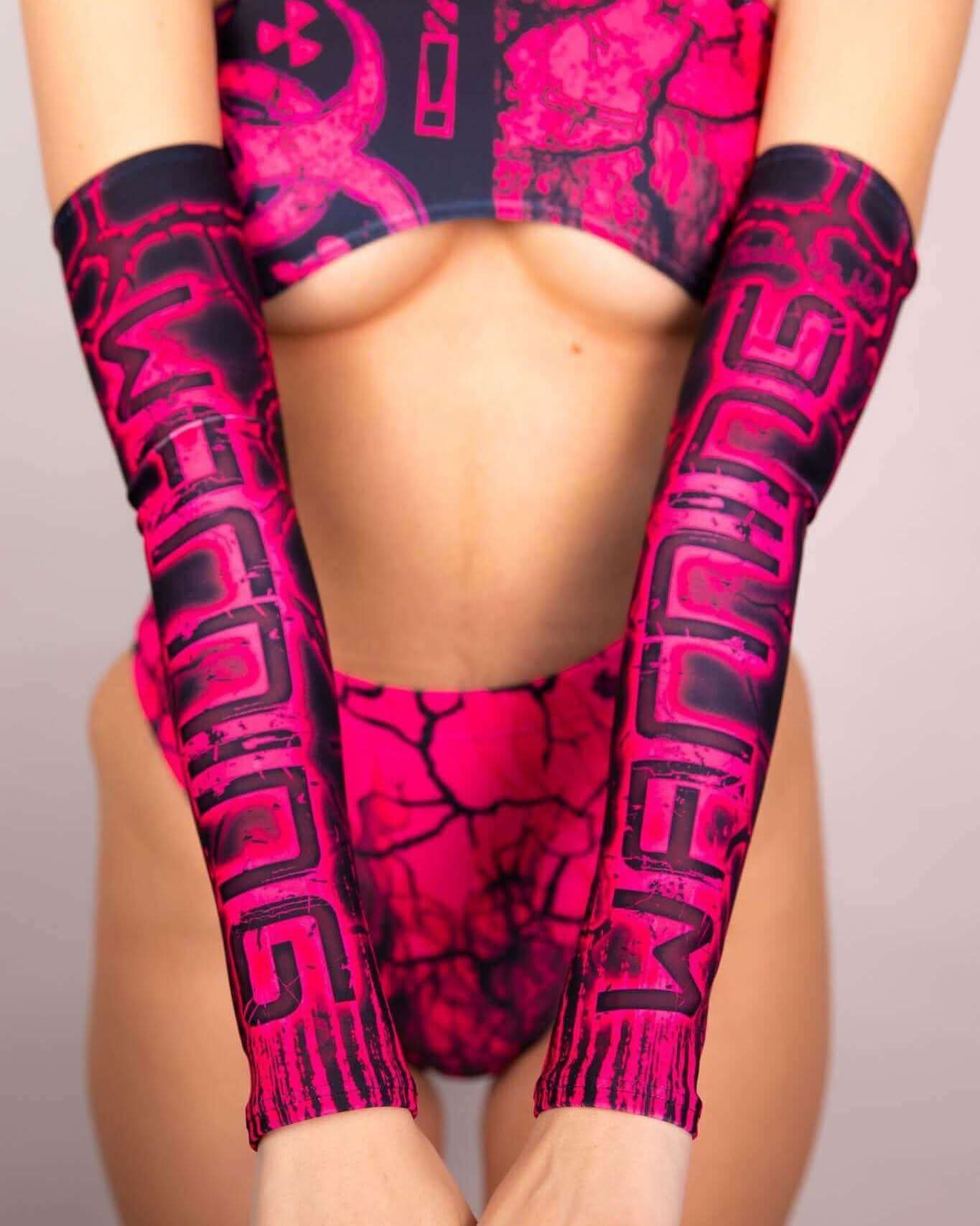 Pink and black toxic arm sleeves worn with a matching rave outfit, showcasing a stylish and vibrant design.