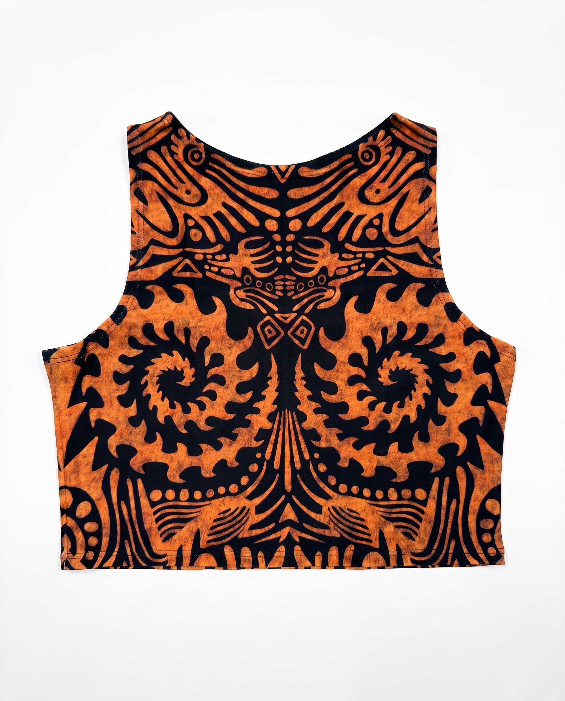 Primal Crop Top, laid flat with orange tribal print on black, a scoop neckline and straight cropped hem