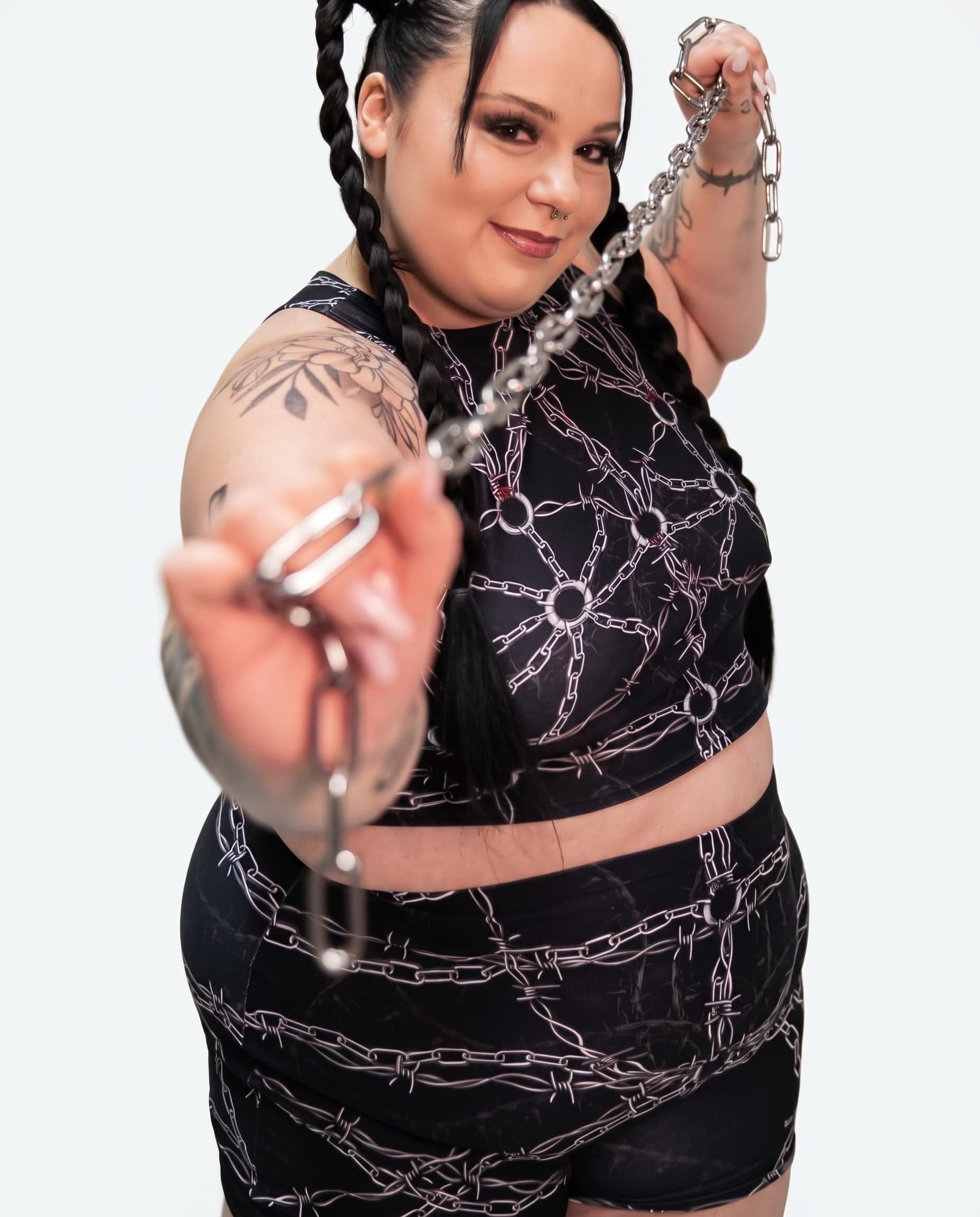 Purgatory Crop Top, three-quarter view of chain and barbed wire print with model holding a silver chain