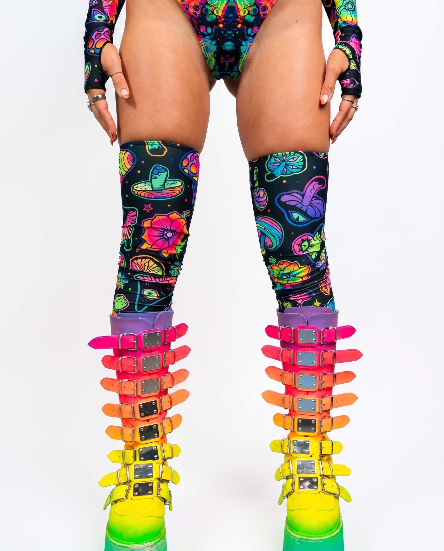 Shroomie Leg Sleeves, front view showing colorful mushroom and flower prints above rainbow buckle boots