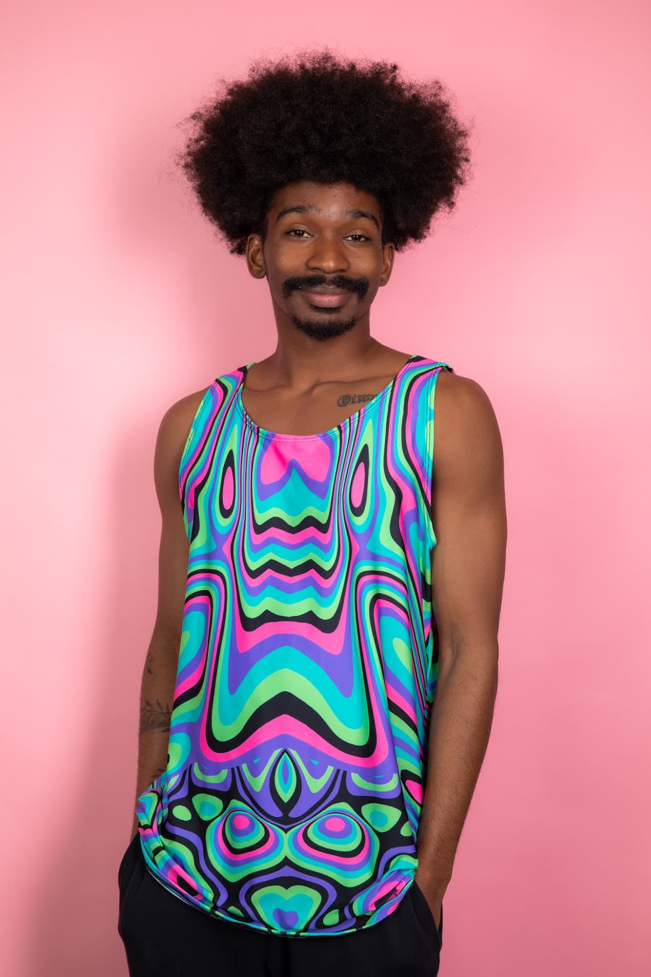 Sugar Rush Unisex Tank Top, front view on model showing pink, aqua, lime and purple swirls against a pink backdrop