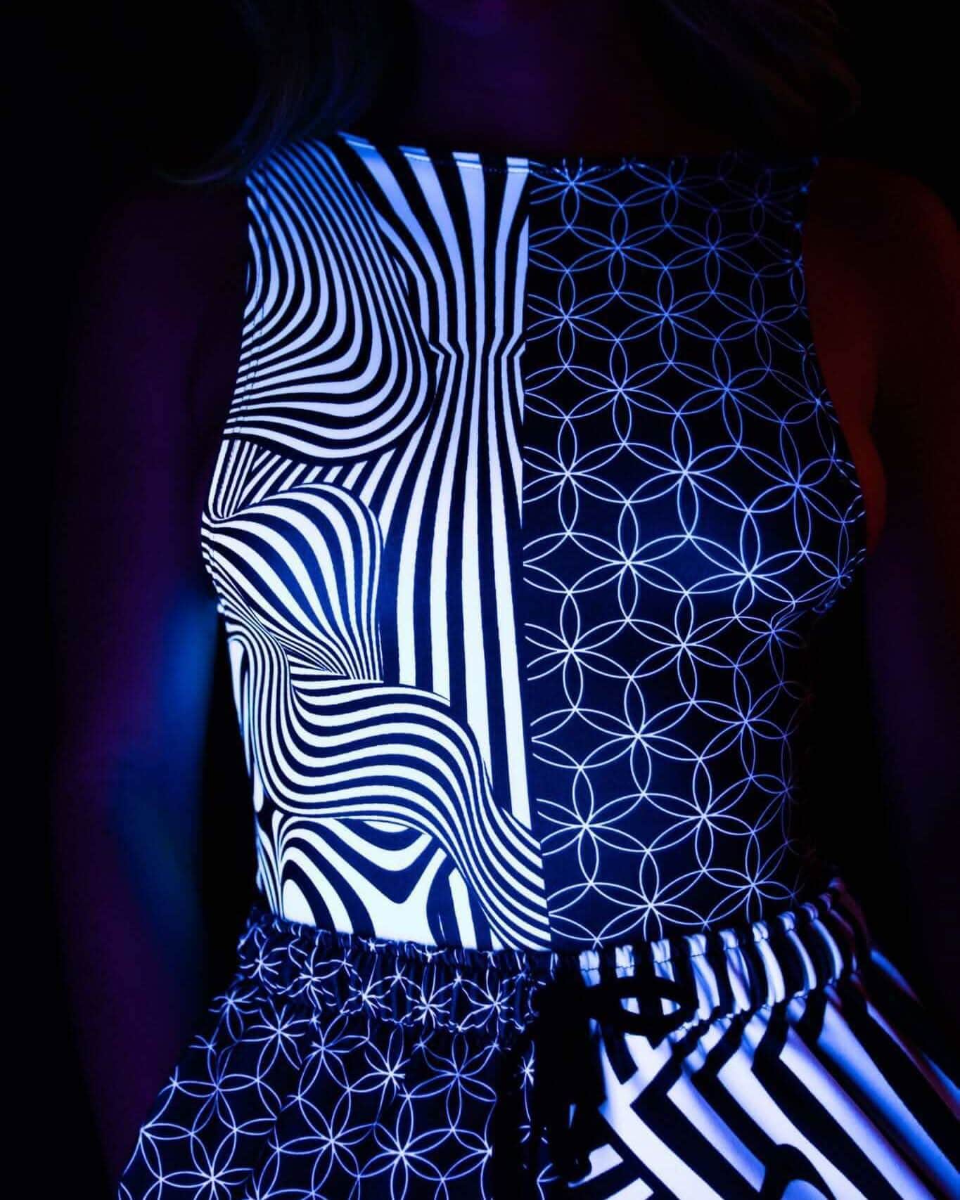 Duality rave bodysuit with black white geometric patterns and sideboob cutouts under UV lighting side view