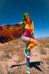 raver wears bright colored desert themed rave outfit in the middle of the California desert
