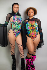 two ravers in coordinating trippy bodysuits and mesh bell sleeves celebrating body inclusivity