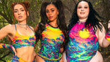 Three women in colorful rave outfits showcasing bold designs and vibrant prints inspired by rave culture.