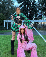 Two rave girls in geometric-patterned colorful rave attire pose dramatically outdoors, channeling a bold festival style