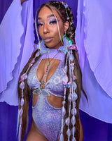 Frontal close-up of a model adorned in a sparkling lavender bodysuit from Freedom Rave Wear, featuring detailed accessories and makeup.
