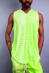 Model in a vibrant green sleeveless hooded top and matching shorts from Freedom Rave Wear, featuring psychedelic patterns.