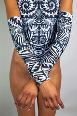 An up-close photo of a girl wearing black and white tribal printed rave arm sleeves with a matching bodysuit.