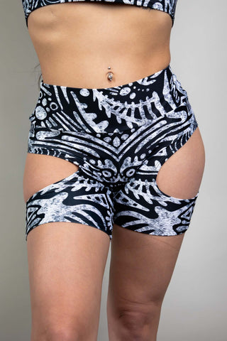 An up close photo of a girl wearing black and white tribal printed bike shorts with cutouts on either side. 