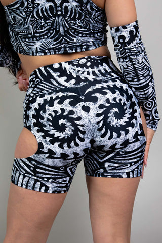 An up close photo of a girl wearing black and white tribal printed bike shorts with cutouts on either side.  She is facing away from the camera.