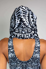 A photo of the back of a girl's head. She is wearing a black and white tribal printed hood and a matching bodysuit.