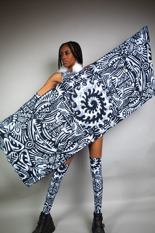 A girl holding up a large black and white tribal printed pashmina in front of her body.