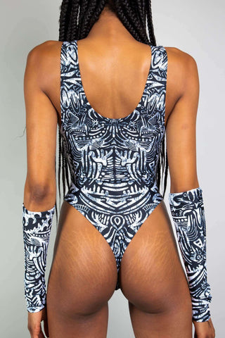 An up close photo of a girl wearing a black and white tribal printed bodysuit with matching arm sleeves. She is facing away from the camera.