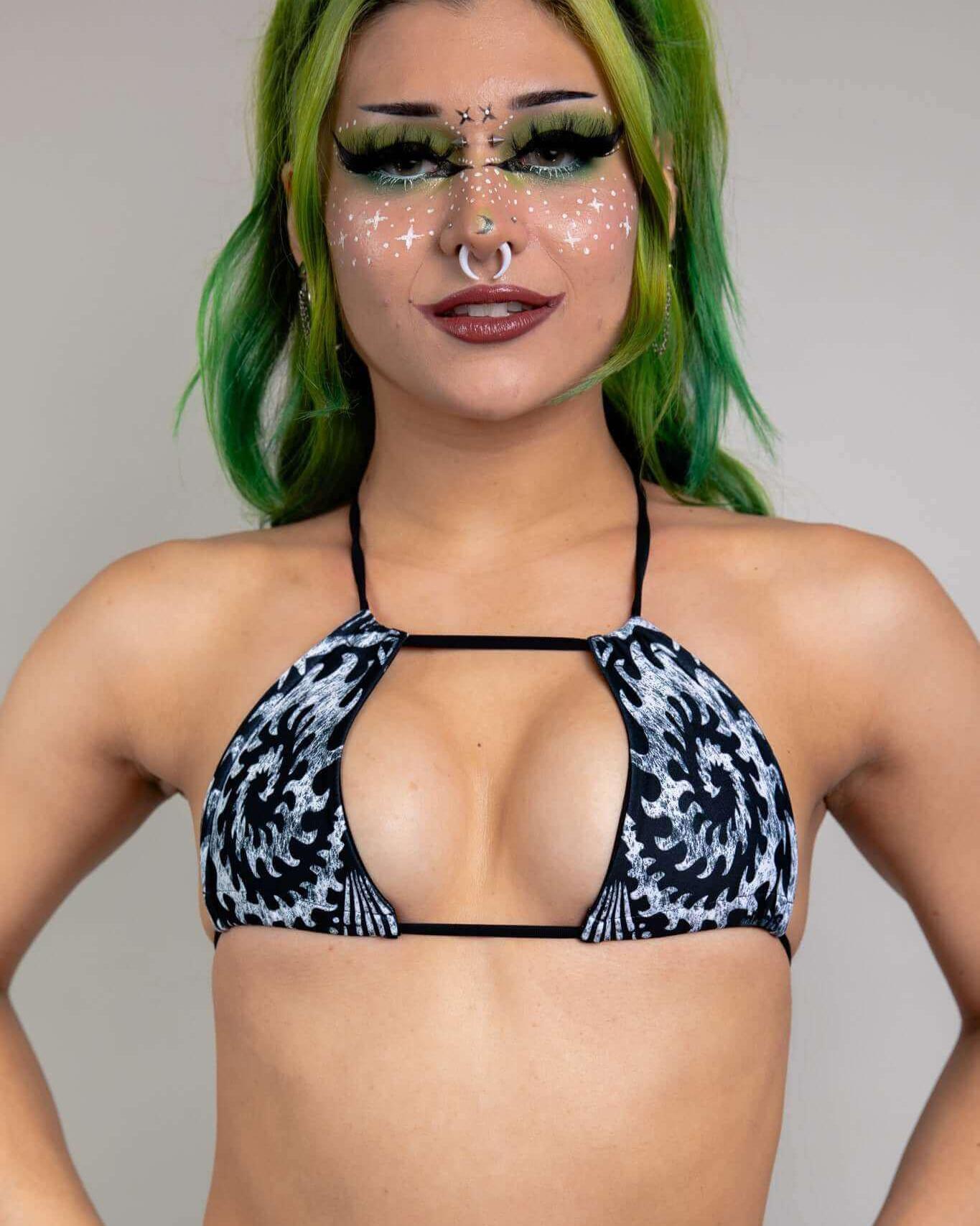 Archaic strappy bikini top featuring unique black and white design, paired with bold makeup and green hair, ideal for rave outfits.