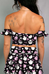 Model in a black off-shoulder bardot top with pink and white spooky ghost print, paired with matching skirt