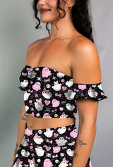 Model in a black off-shoulder bardot top with pink and white spooky ghost print, paired with matching skirt