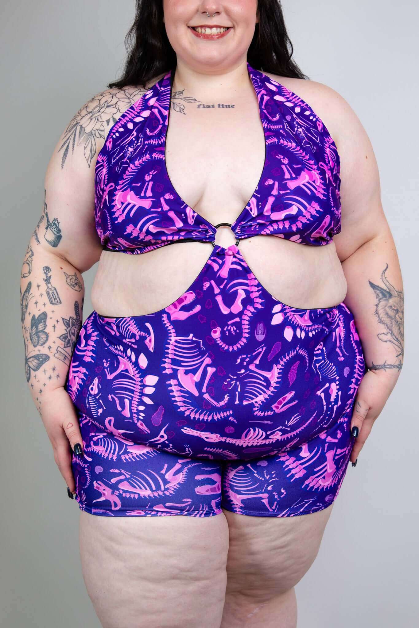 Model wearing Freedom Rave Wear romper with a purple dinosaur print, perfect for a fun and stylish rave outfit.