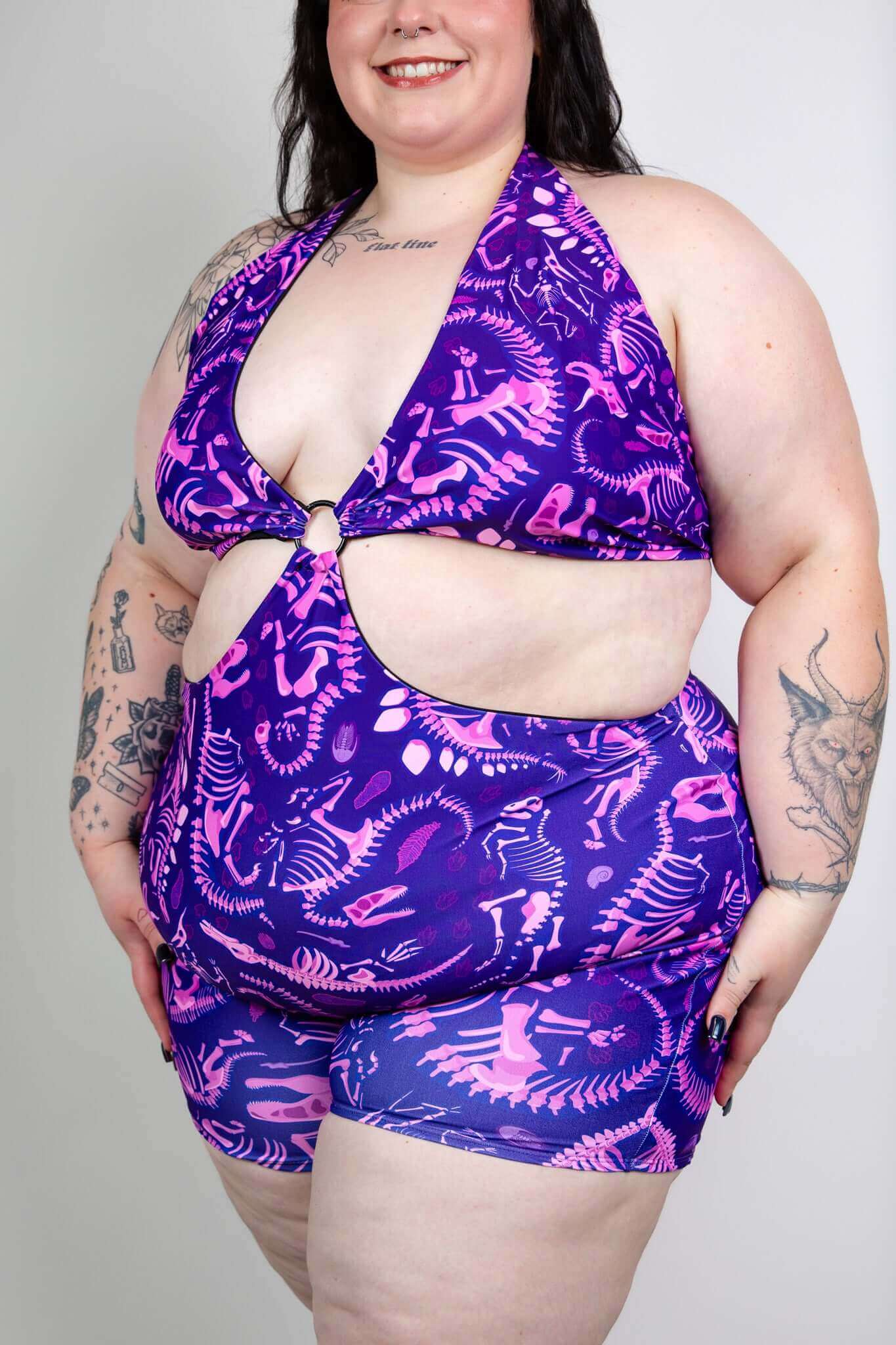 Model wearing Freedom Rave Wear romper with a purple dinosaur print, perfect for a fun and stylish rave outfit.