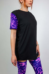 Model wearing Freedom Rave Wear black t-shirt with purple dinosaur print sleeves and matching leg sleeves, perfect for raves.