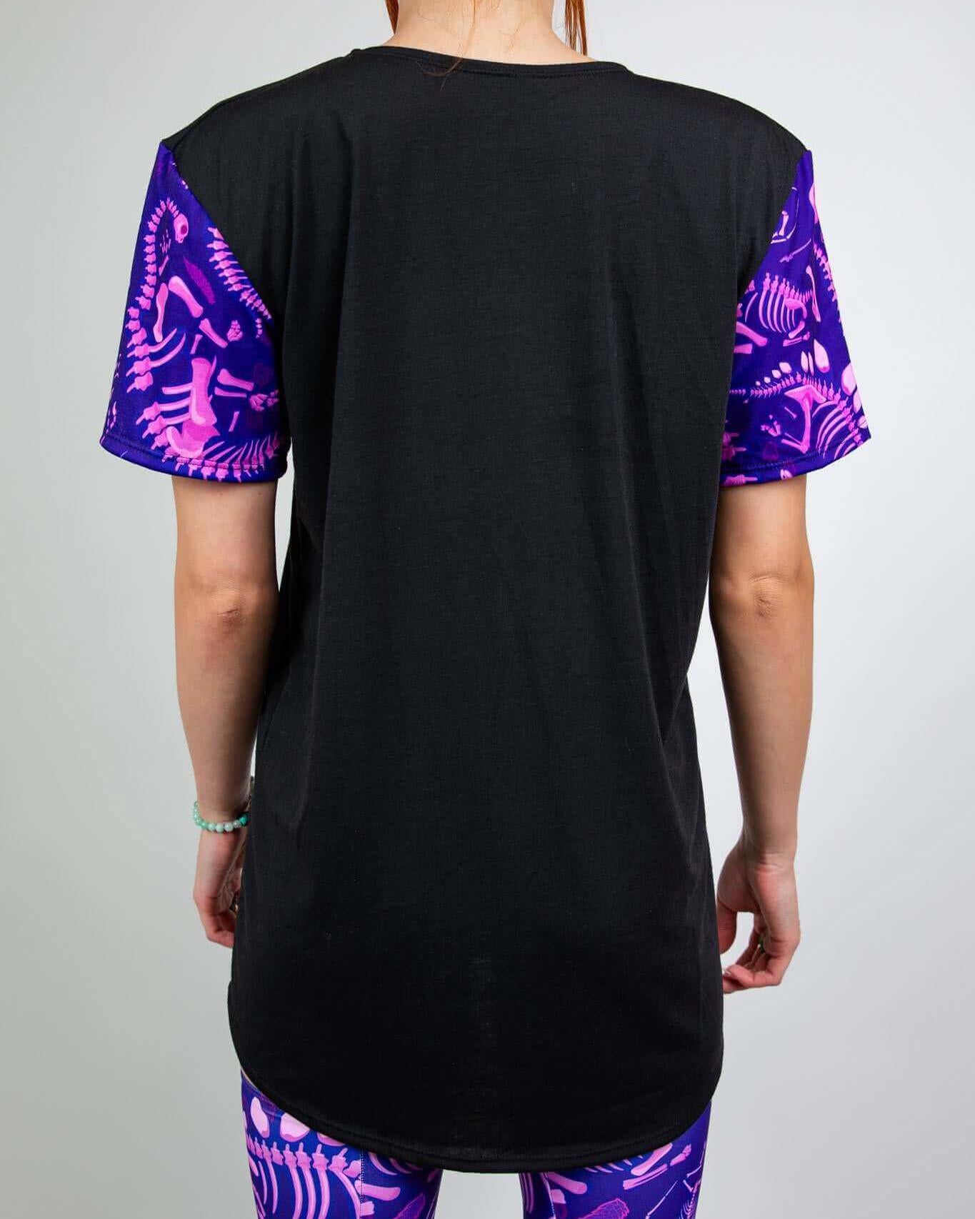 Back view of Baby Steps unisex t-shirt featuring black base and purple dinosaur fossil sleeves, perfect for rave outfits.