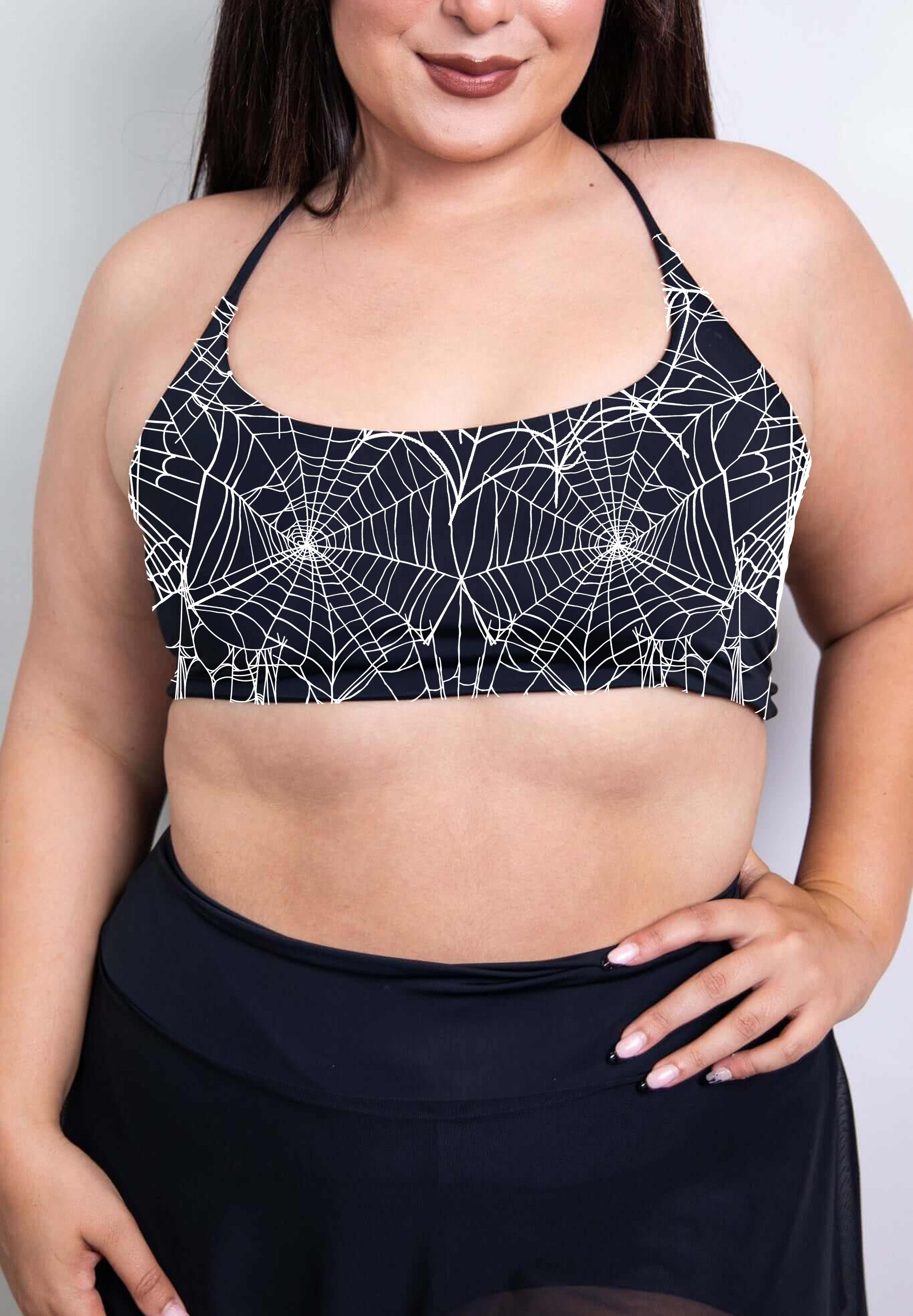 A black halter crop top with a striking spider web pattern in white, designed to turn heads with its gothic, sleek style.