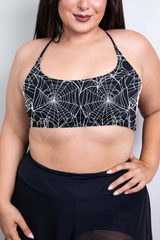 A black halter crop top with a striking spider web pattern in white, designed to turn heads with its gothic, sleek style.