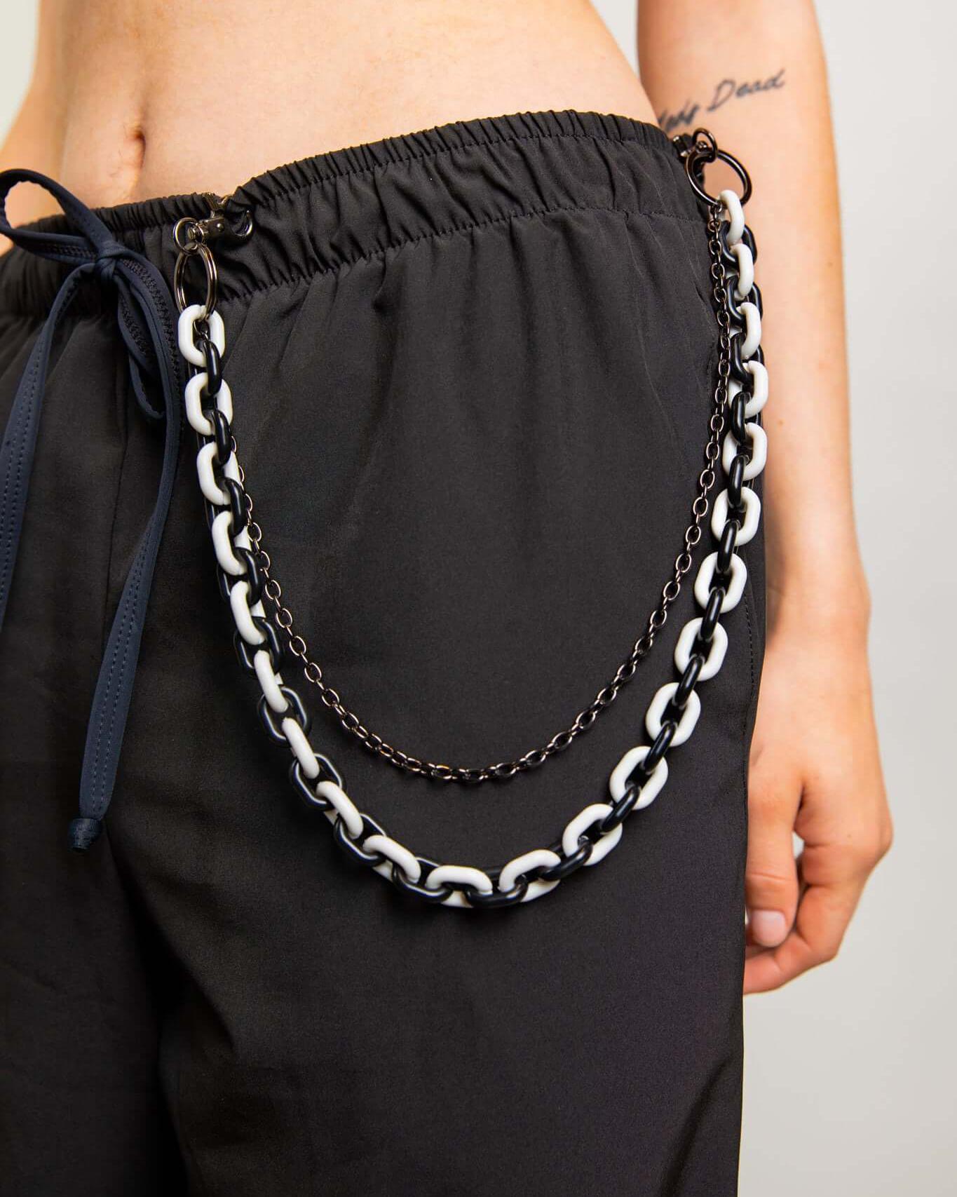 Black and white Balance Chain body chain accessory styled with casual pants for rave outfits.