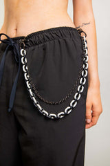 Black and white Balance Chain body chain accessory styled with casual pants for rave outfits.