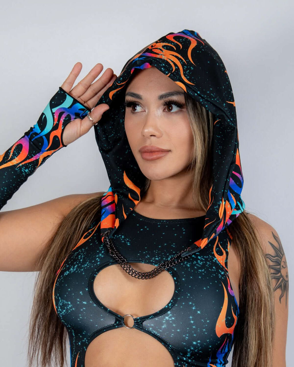 Woman wearing Blaze Assassin Hood with cosmic flame print, styled for rave outfits and festival fashion.