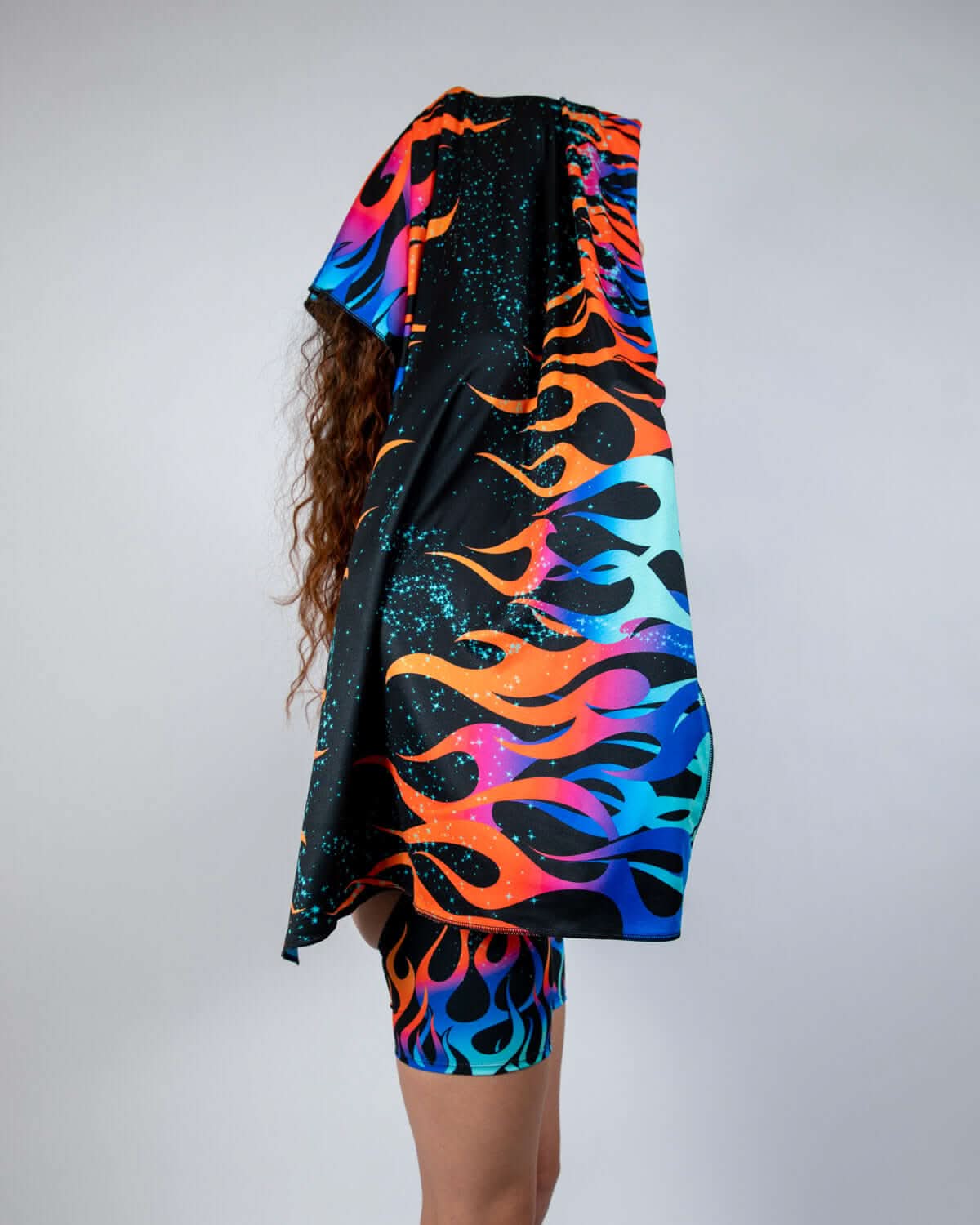 Model wearing Blaze Festival Scarf featuring vibrant neon flames and cosmic backdrop, perfect for rave outfits.