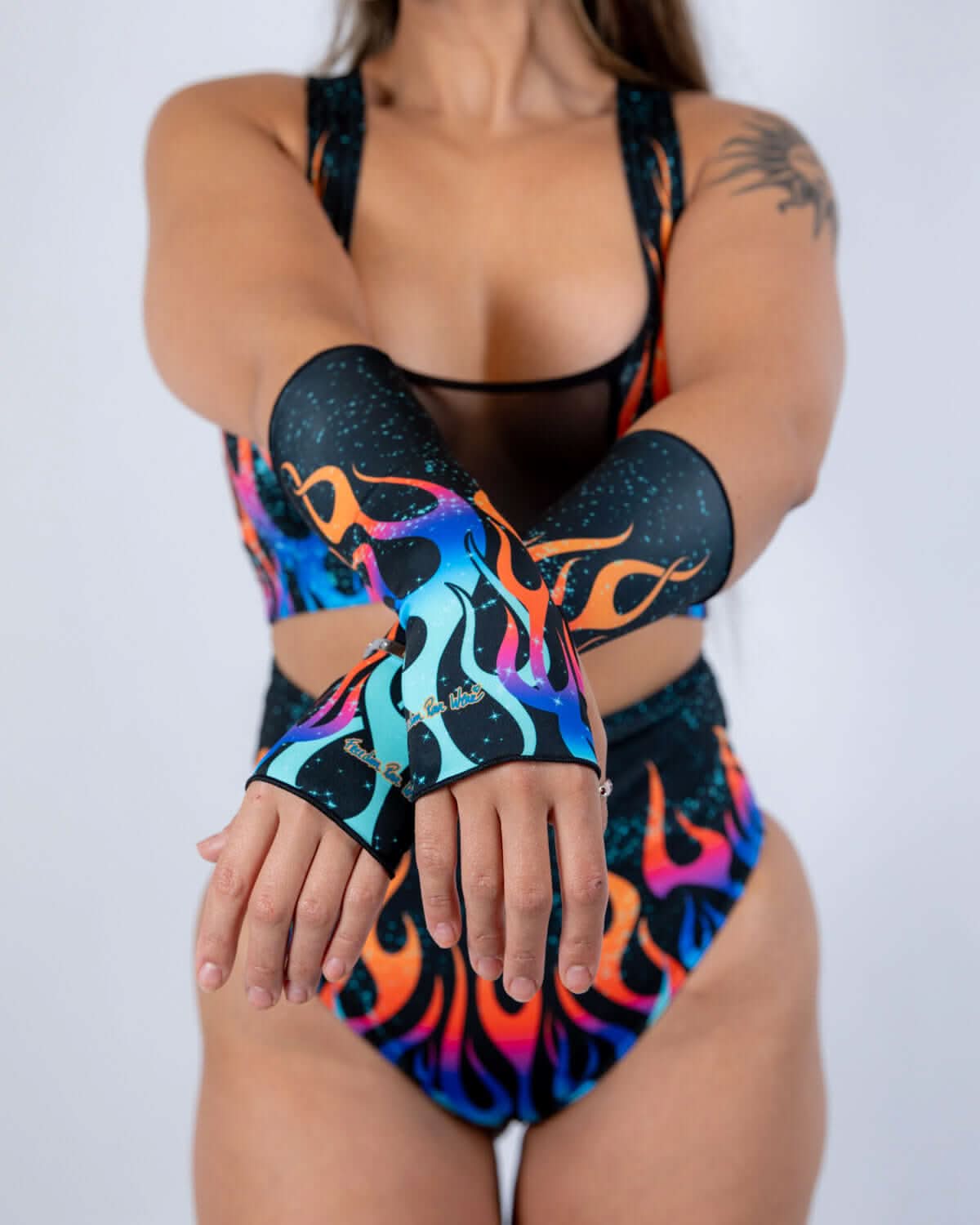 Rave arm sleeves in Blaze flame pattern - model poses with colorful festival outfit sleeves