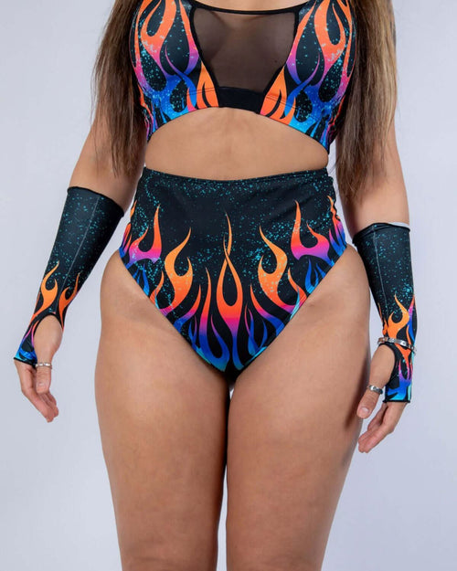 Woman modeling Blaze high waisted rave pants with colorful flame print and matching arm sleeves for festival outfits