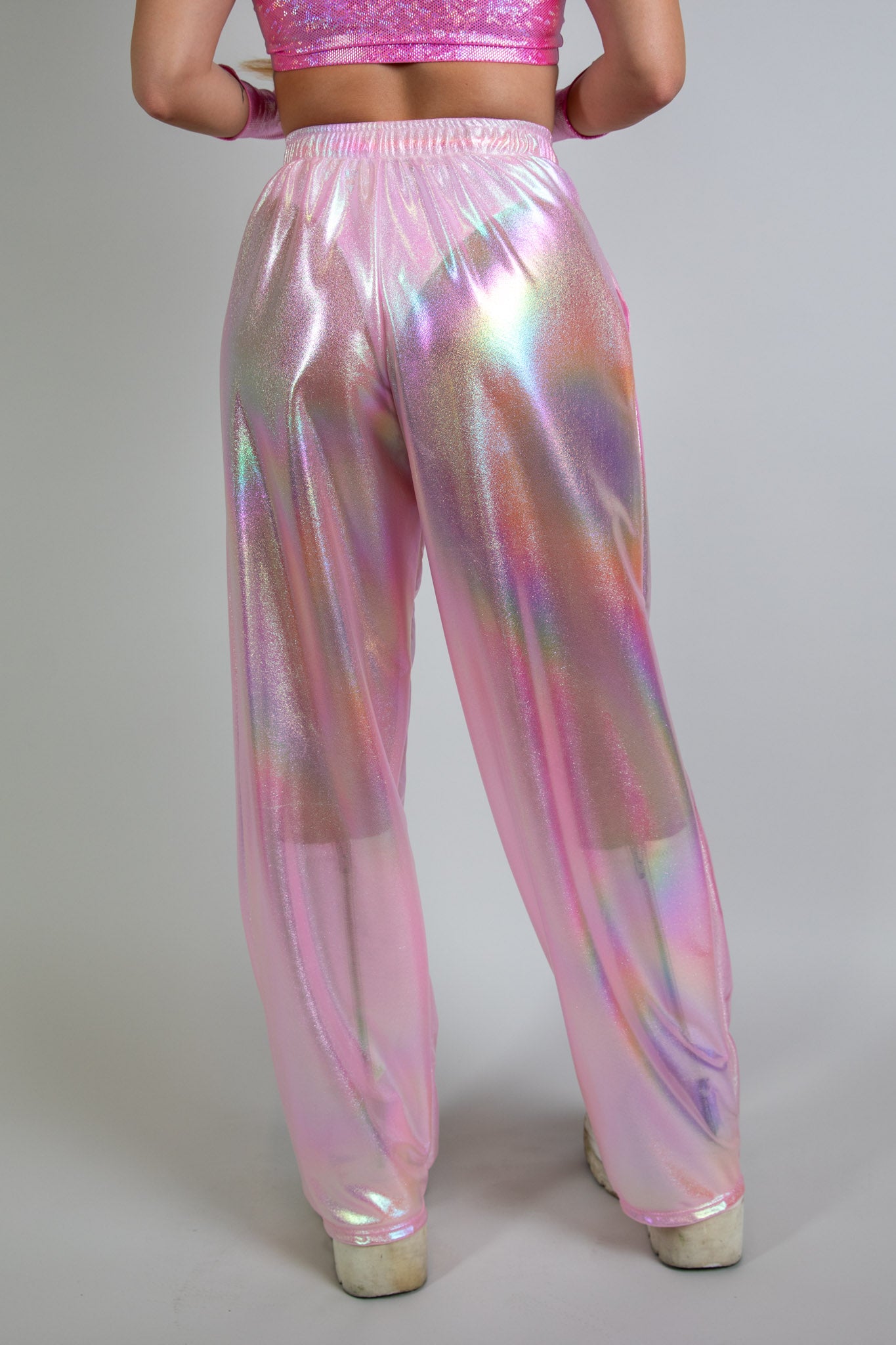 Bubble Gum Lucy Pants in iridescent pink, front view, high-waisted design with relaxed fit and shimmering fabric, ideal for rave fashion and festival style.