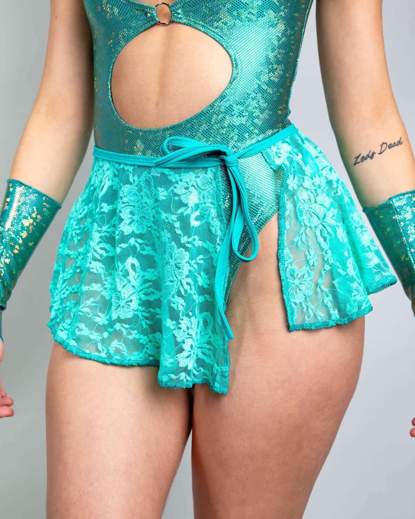 Model wearing the Calypso Lace Swirl Skirt over a bodysuit, showcasing a vibrant lace design, perfect for rave outfits.