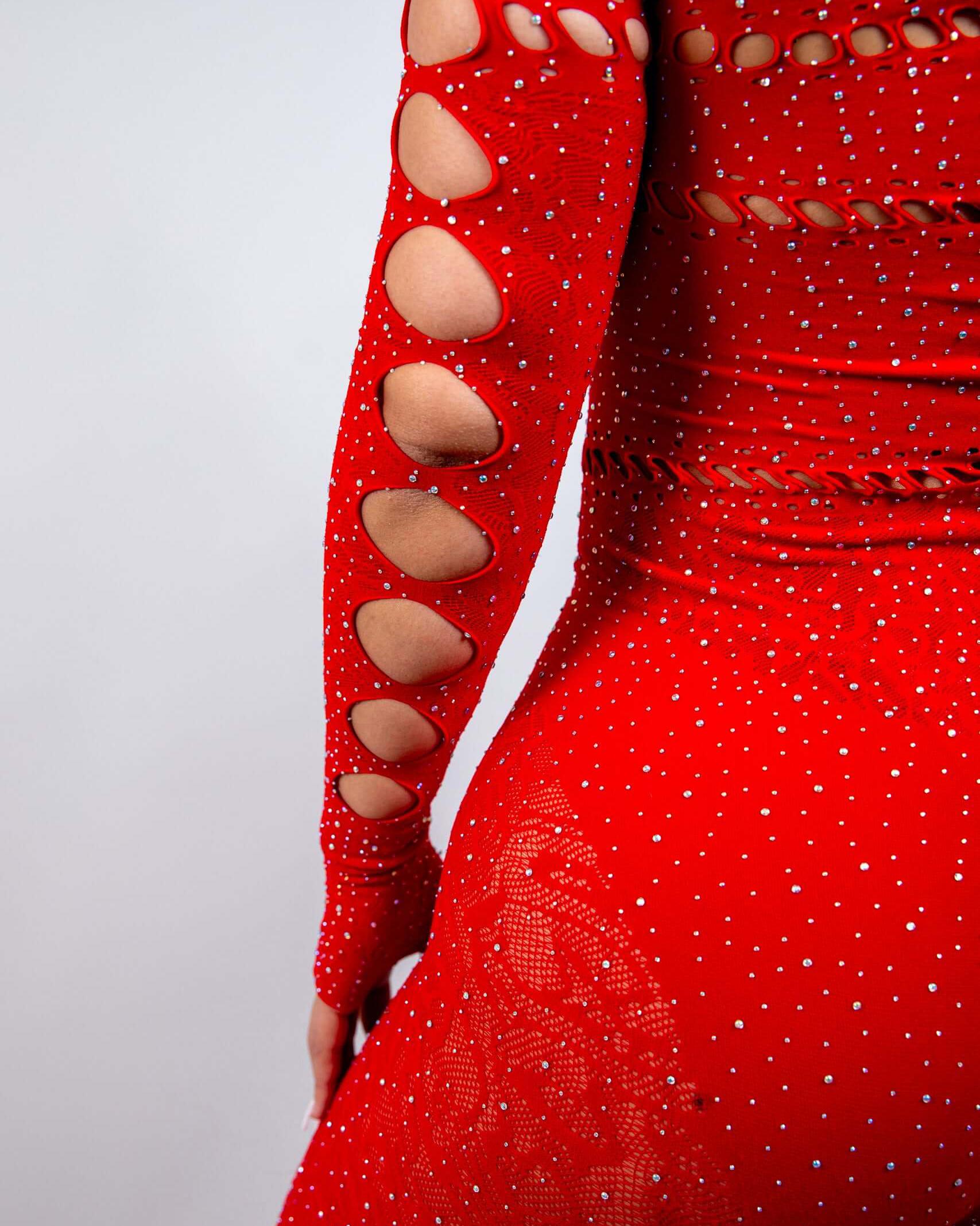 Close-up of the Camilla Rhinestone Off the Shoulder Jumpsuit in red, featuring cutouts and sparkling rhinestones, perfect for rave outfits.