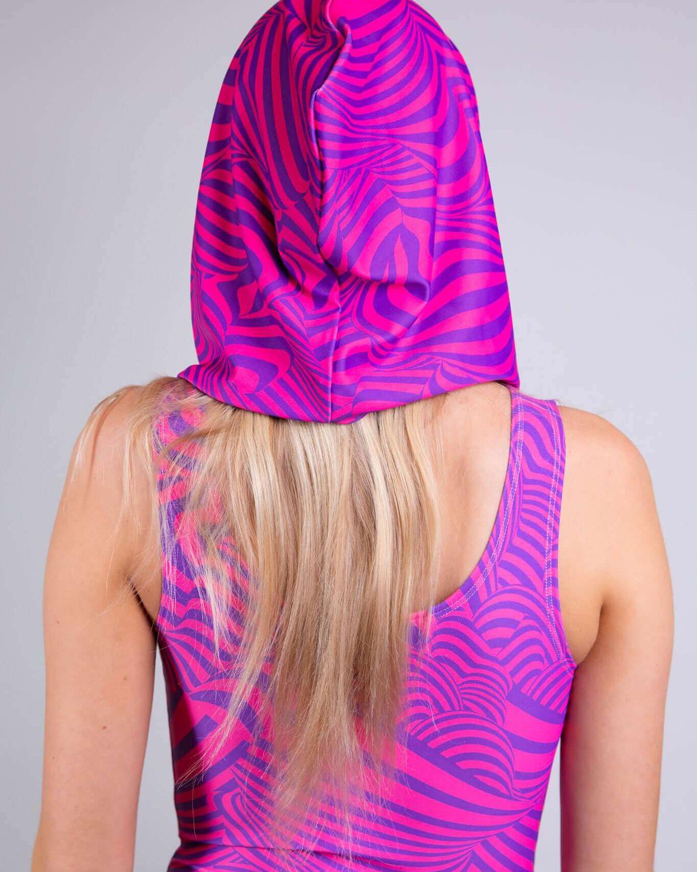 Back view of a model wearing a vibrant pink striped Cheshire Assassin Hood, perfect for rave outfits and festivals.